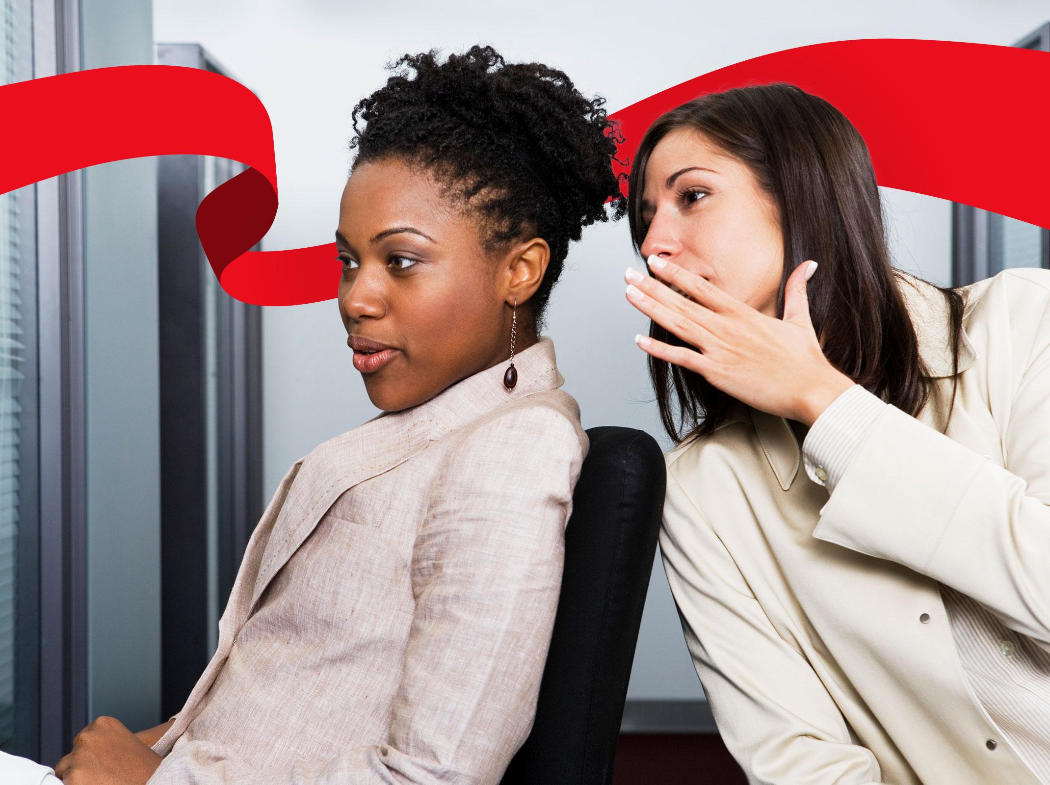 Woman whispering to to a co-worker in the office