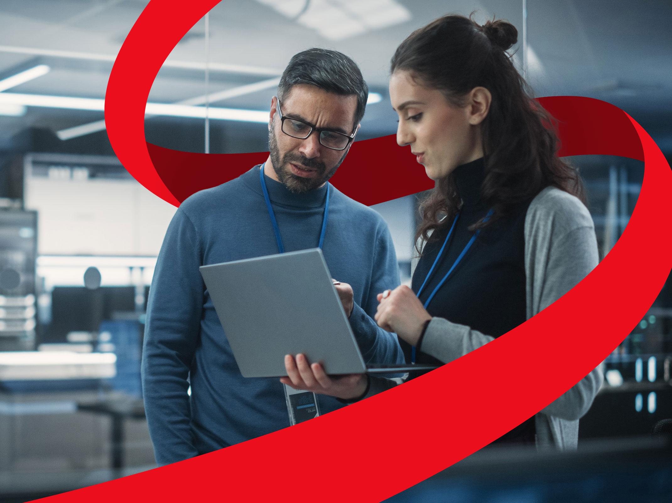 Two cybersecurity experts looking at computer