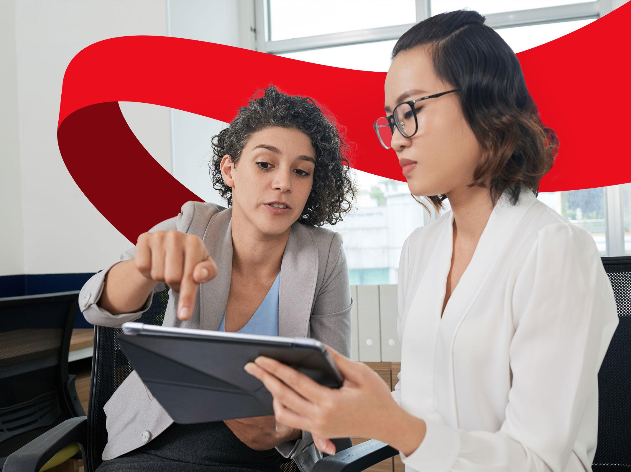 Two business professionals reviewing something on a tablet in a business setting.  One person is gesturing dramatically at the tablet.