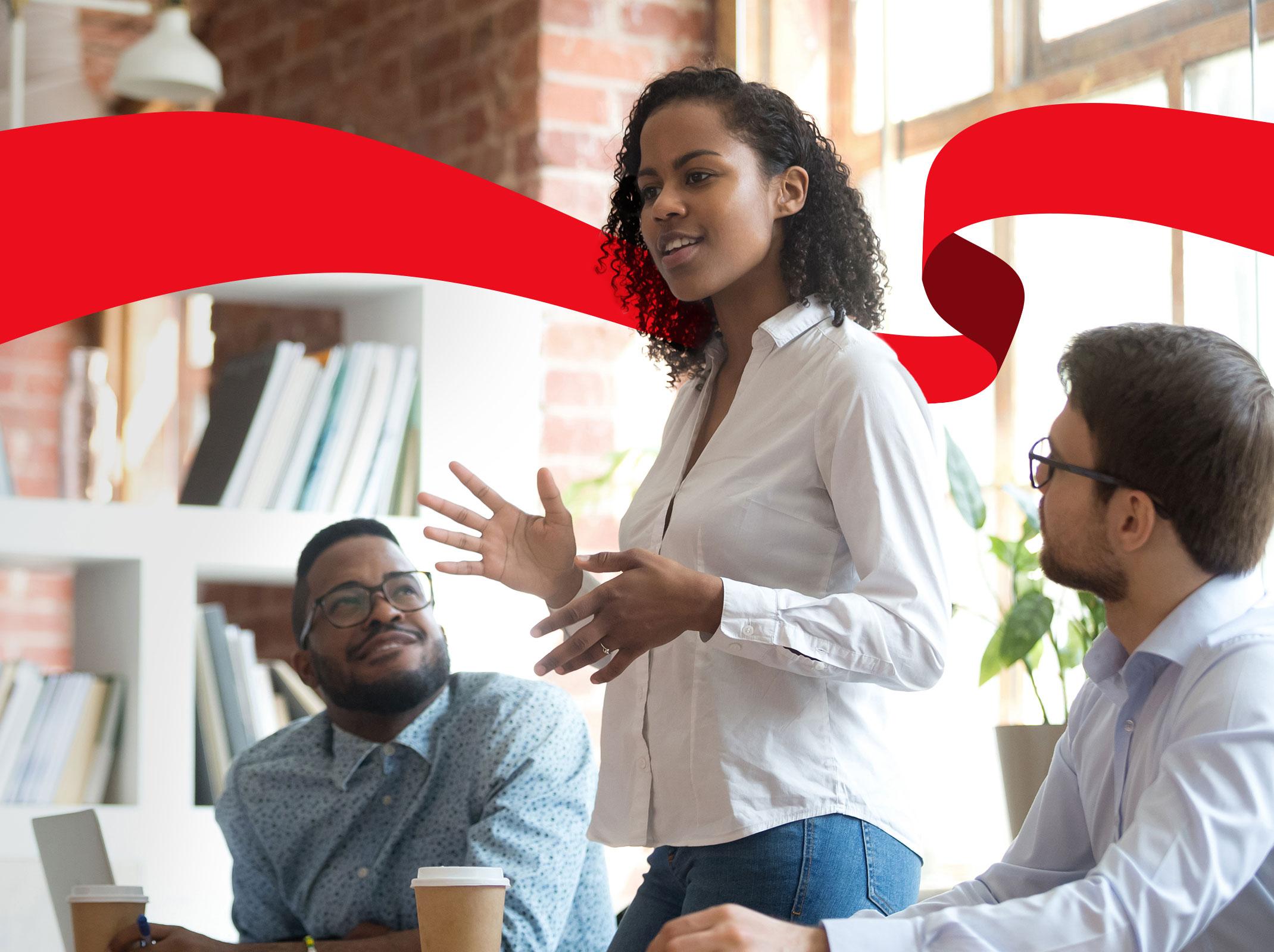 Business professional at a table using her authority to address a group of colleagues.